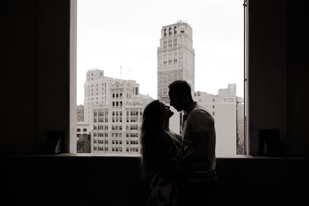 Couple framed by detroit city scape fall engagement session